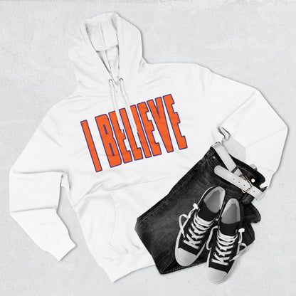 White hoodie with 'I BELIEVE' text, black jeans, and black sneakers on a light gray background