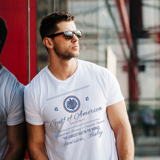 Man wearing a white t-shirt with text and graphics, standing outdoors.