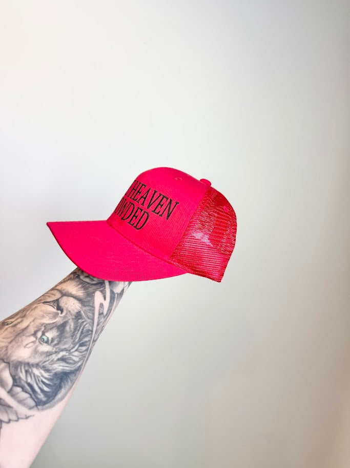 Red cap with 'MAKE HEAVEN CROWDED' text held by a tattooed arm against a light gray background