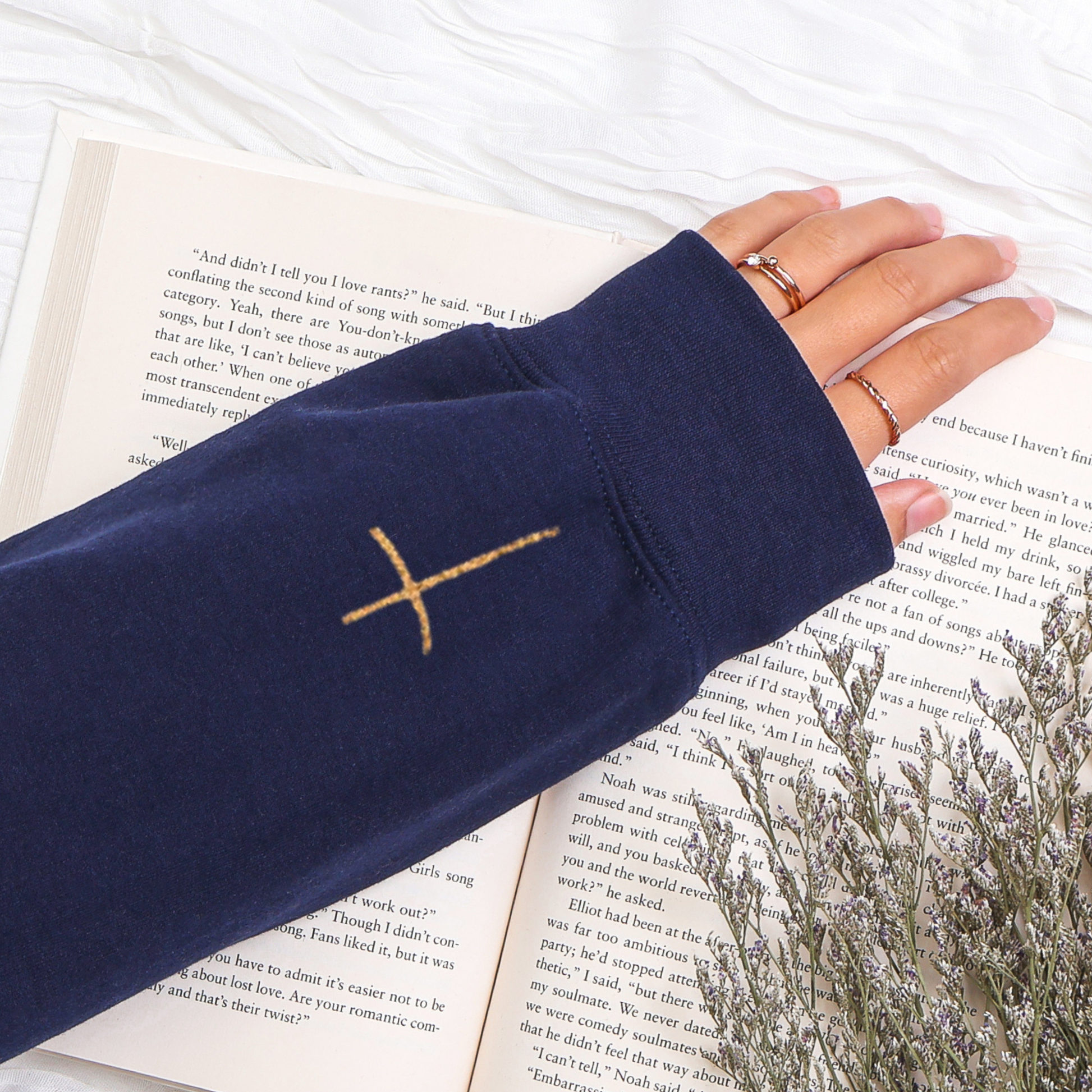 Navy blue sleeve with a gold cross design on a book