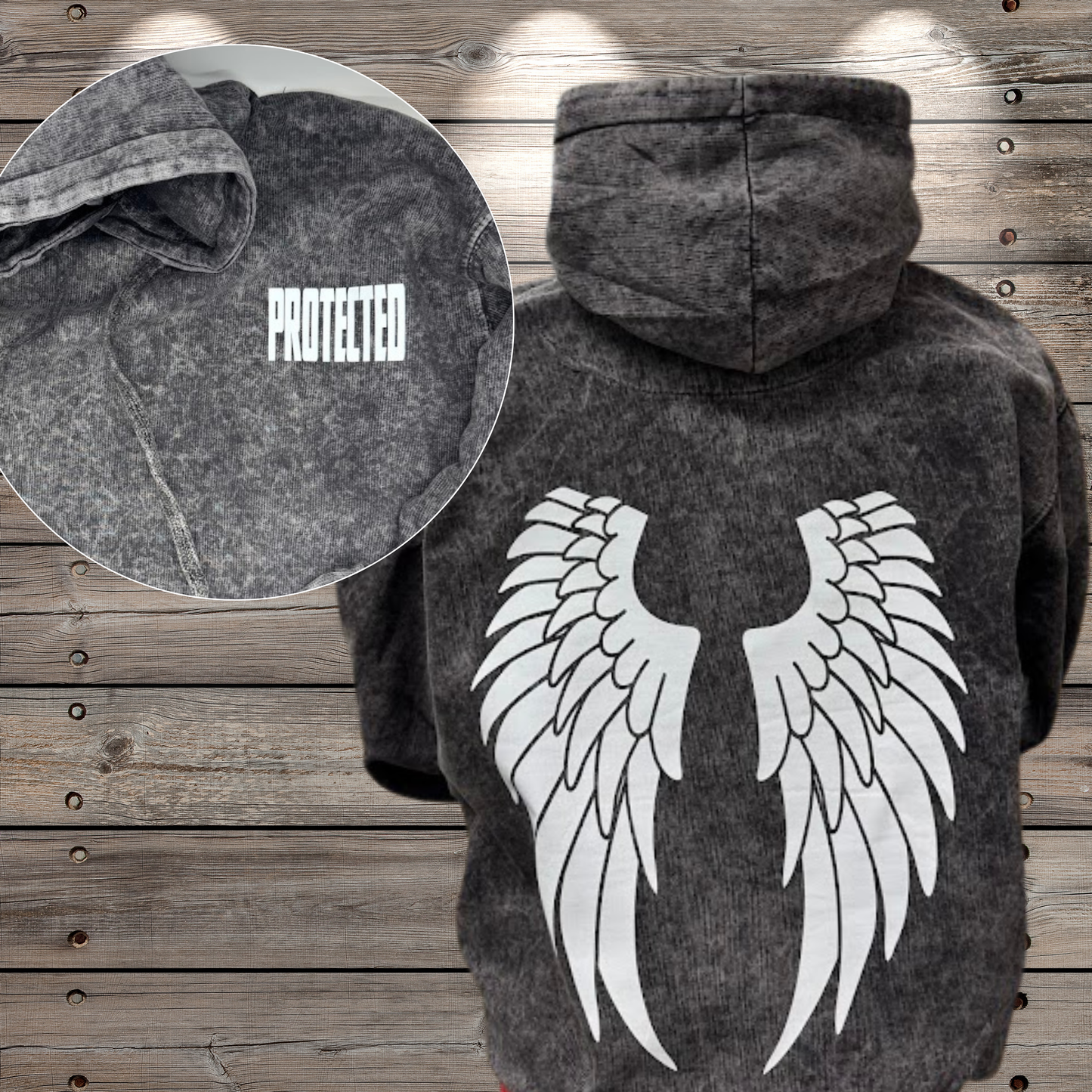 Dark hoodie with angel wings design on a wooden background