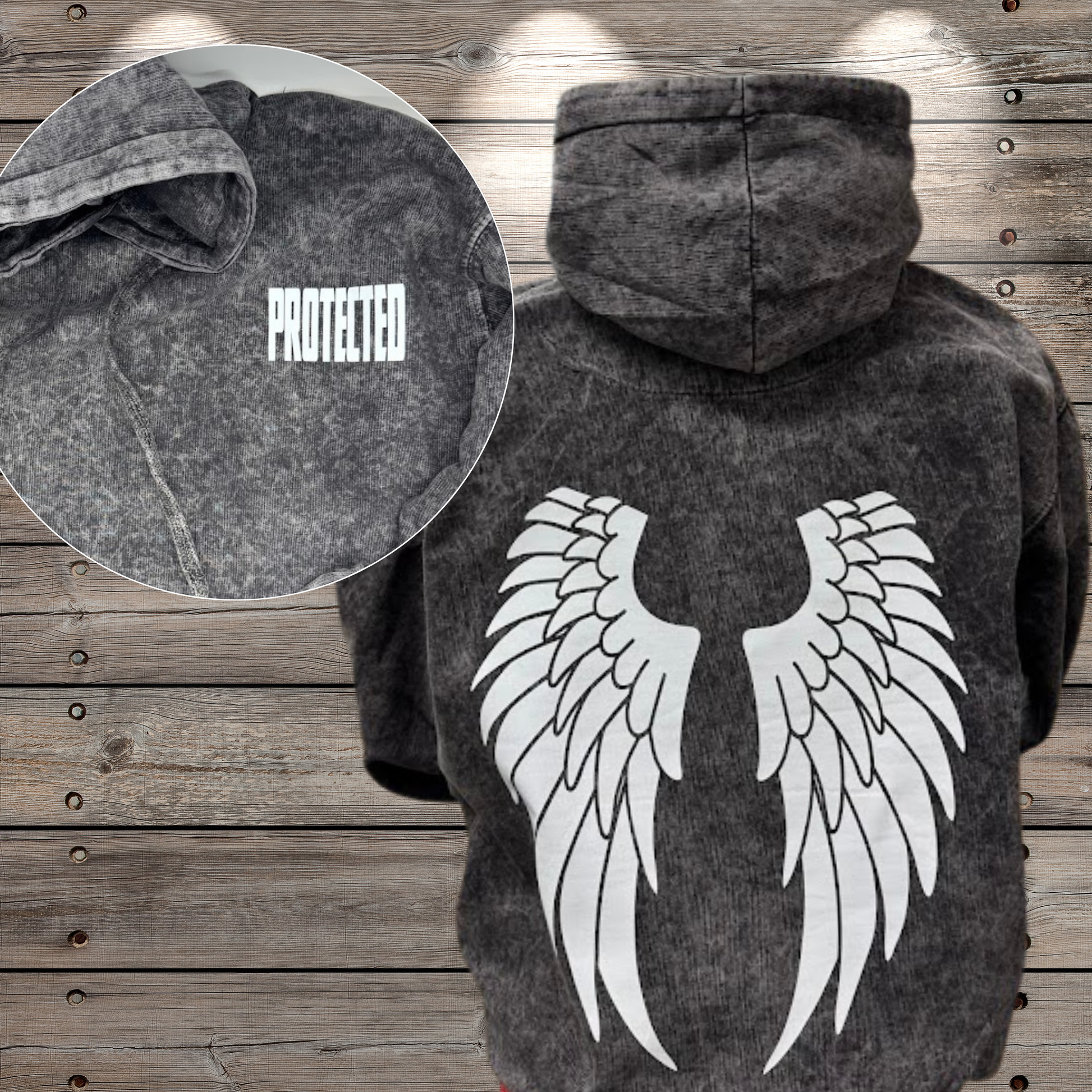 Dark hoodie with angel wings design on a wooden background