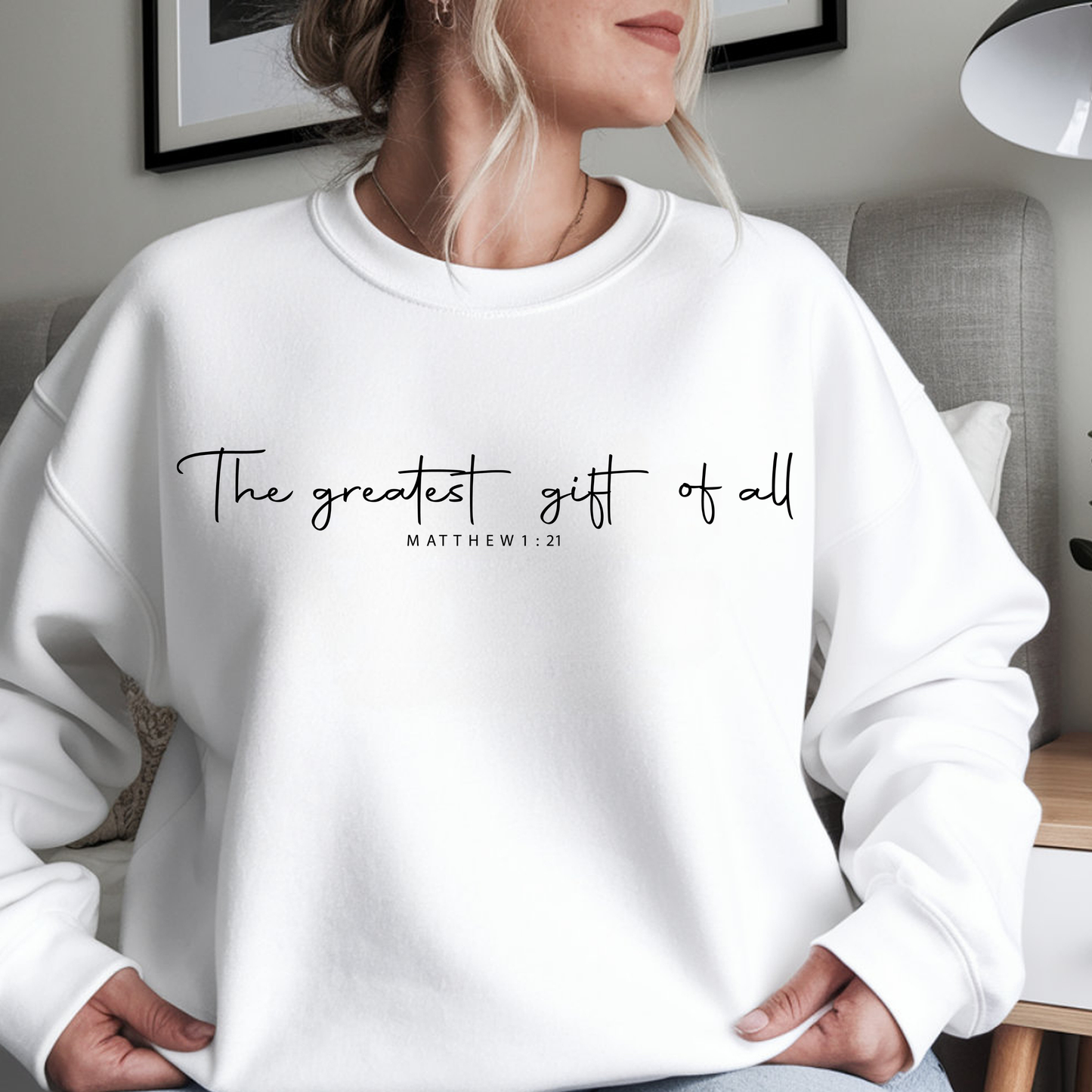 Person wearing a white sweatshirt with text in a home setting
